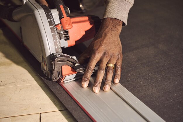 Foto gekapte hand van een timmerman die in een werkplaats werkt