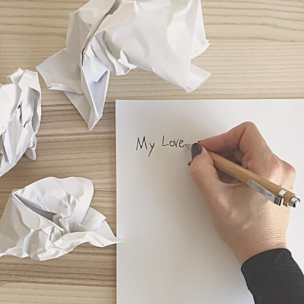 Foto gekapte hand van een vrouw die een brief schrijft