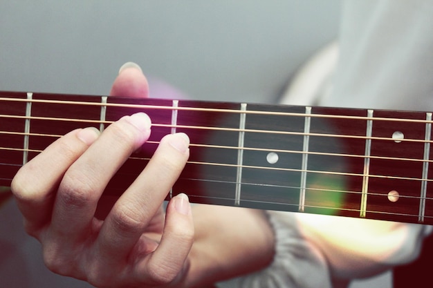 Gekapte hand van een vrouw die gitaar speelt