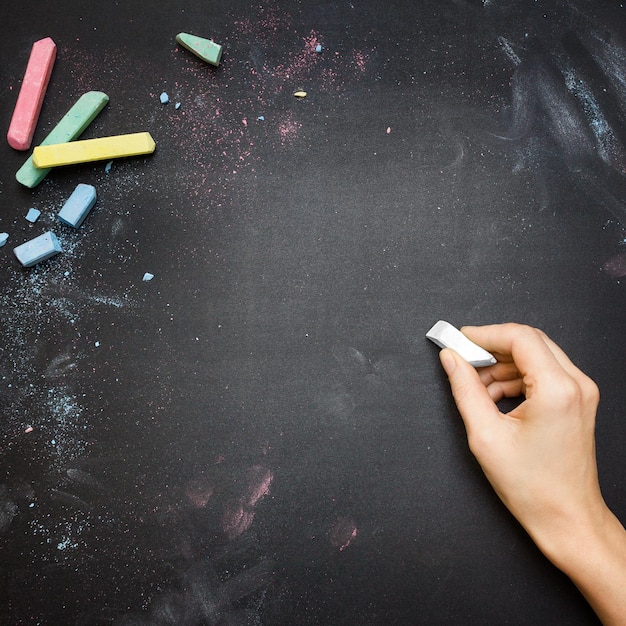 Foto gekapte hand van een vrouw die op het bord schrijft