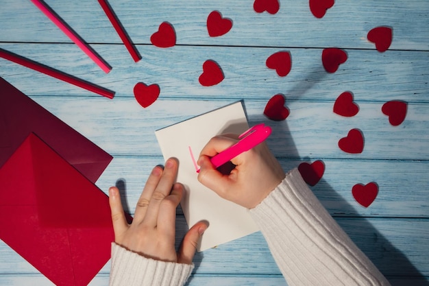 Gekapte hand van een vrouw die op tafel schrijft