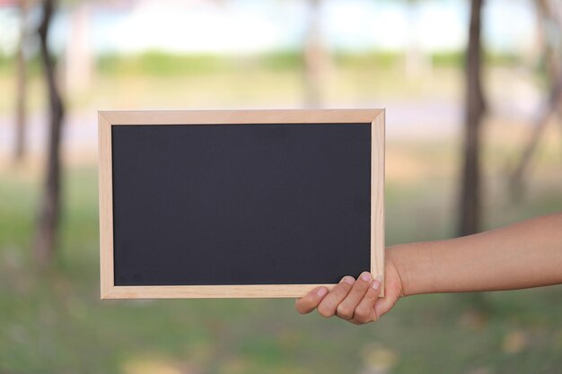 Foto gekapte hand van een vrouw met een schoolbord