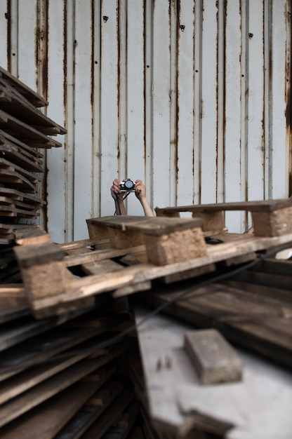 Foto gekapte handen die de camera bij hout vasthouden