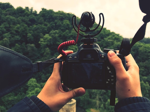 Foto gekapte handen die de camera vasthouden.