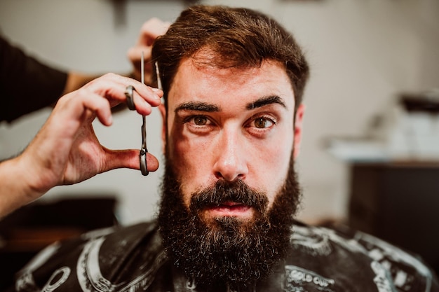 Gekapte handen van een kapper die een klant in een salon verzorgt