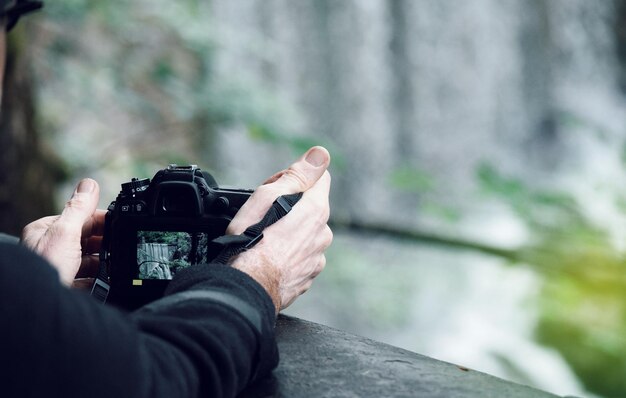 Foto gekapte handen van een man die fotografeert.