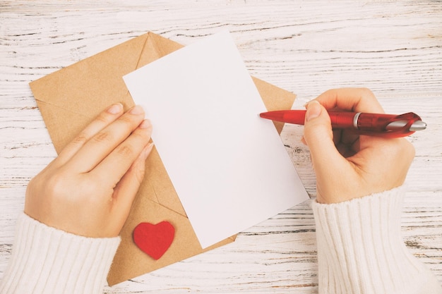 Gekapte handen van een vrouw die op tafel schrijft.