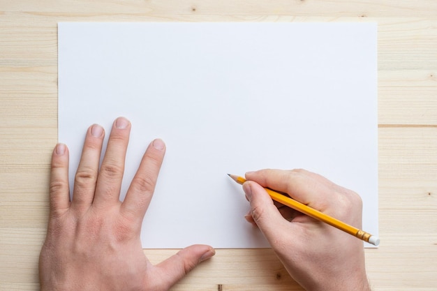 Foto gekapte handen van persoon met pen en papier op tafel