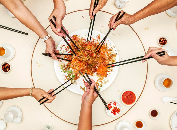 Foto gekapte handen van vrienden die aan tafel eten.
