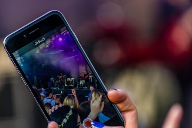 Foto gekapte handfilming met mobiele telefoon tijdens een concert