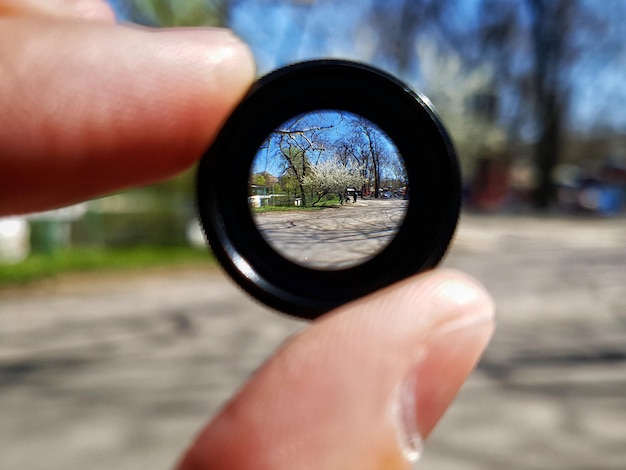 Gekapte handhoudende lens op de weg in de stad