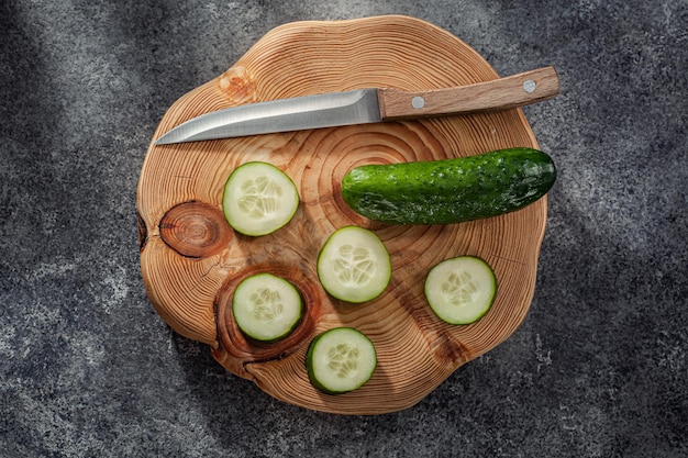 Gekapte komkommer met keukenmes op snijplank