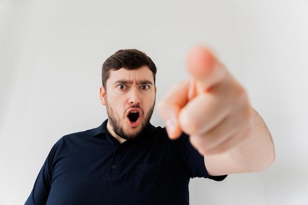 Gekke, bebaarde man schreeuwend naar de camera kijkend en wijzend naar camera studio shot man met intense e