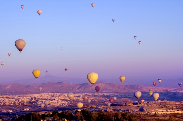 Gekleurde ballonnen bij dageraad klappen over de vallei.