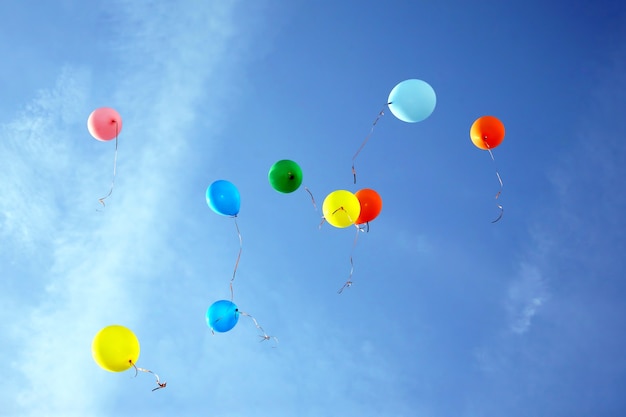 Gekleurde ballonnen vliegen in de blauwe lucht