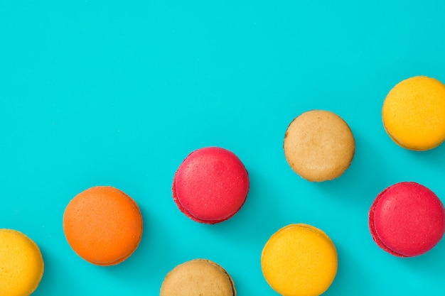 Gekleurde bitterkoekjes op blauwe achtergrond