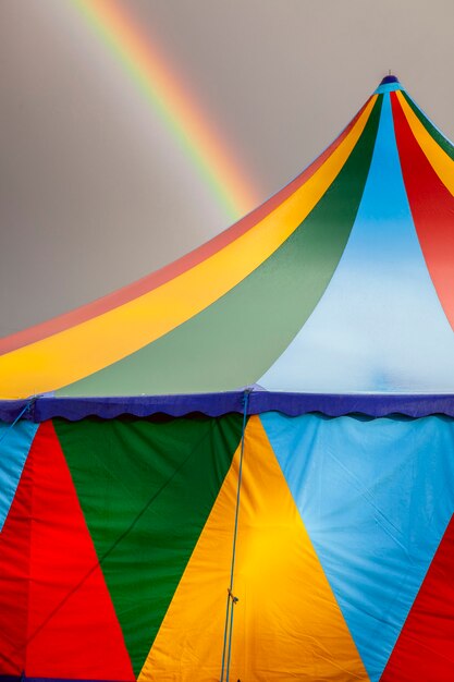 Gekleurde circustent op een regenachtige dag met een regenboog aan de hemel