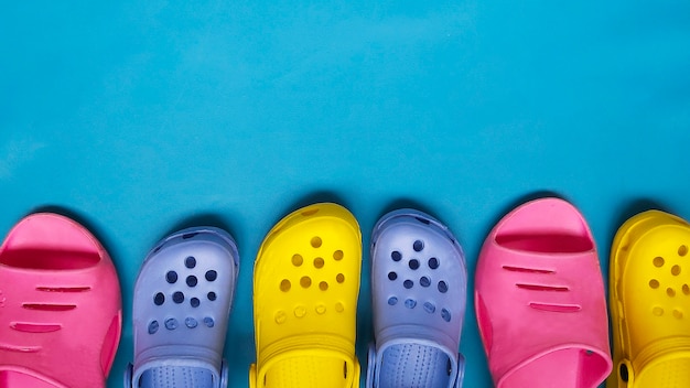 Gekleurde heldere slippers voor vrouwen en kinderen op blauwe achtergrond