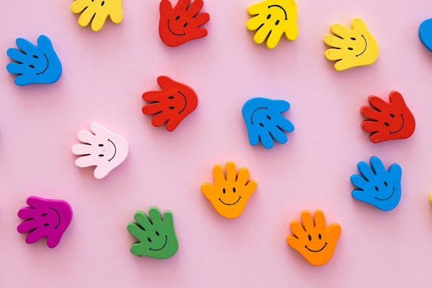 Gekleurde houten figuren in de vormhand met een glimlach op een roze achtergrond