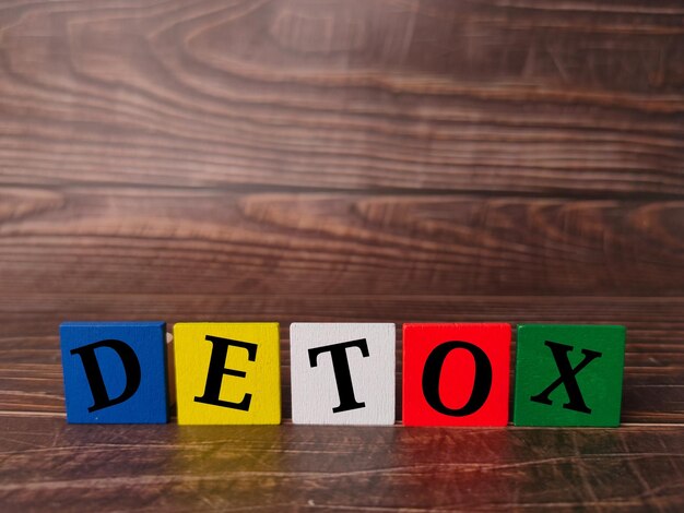 Gekleurde houten kubus met tekst DETOX op een houten achtergrond