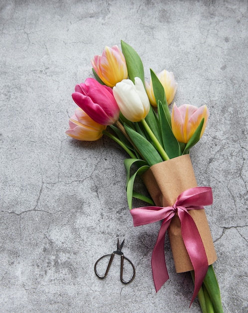 Gekleurde lentetulpen op een betonnen bureau