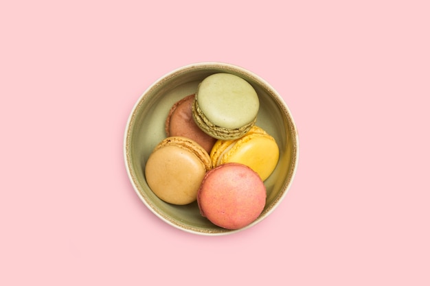 Gekleurde macarons in een groene kom