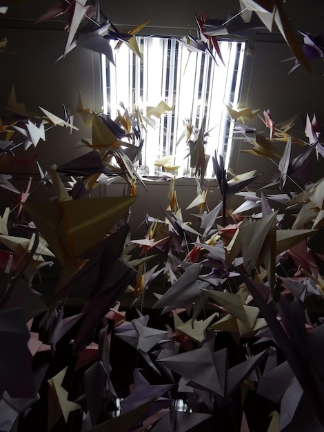 Gekleurde papieren origami kraanvogels onder plafondlamp