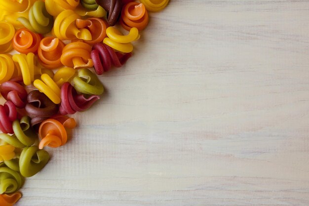 Gekleurde pasta in de vorm van een spiraal Droge Italiaanse pasta in vijf kleuren ruimte voor tekst