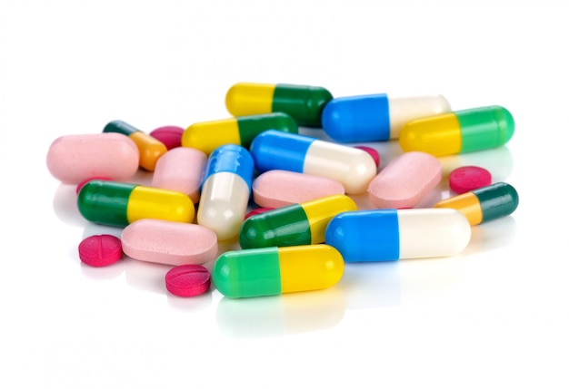 Gekleurde pillen, tabletten en capsules op een witte achtergrond