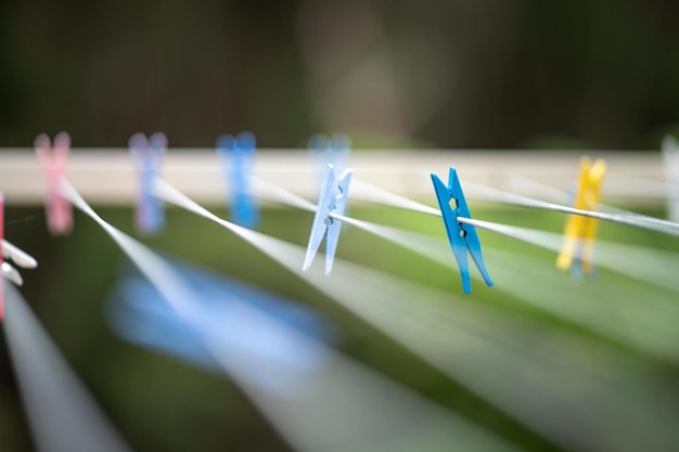 Gekleurde pinnen aan waslijn buiten een huis