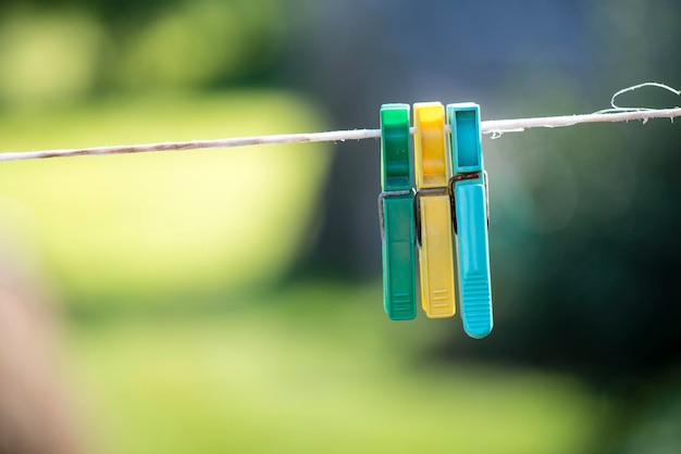 Gekleurde wasknijpers die aan een wit touw hangen