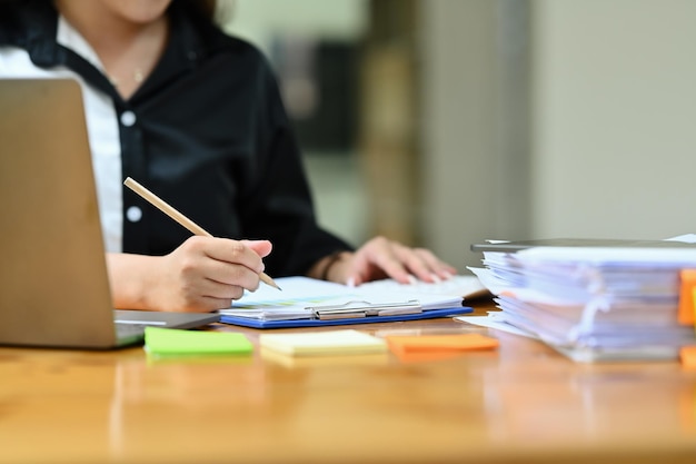 Geknipte afbeelding van een professionele zakenvrouw die een bedrijfsstrategie schrijft en een contract ondertekent bij