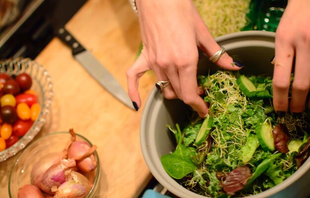 Foto geknipte handen die salade bereiden