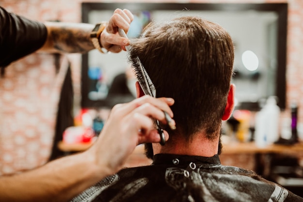 Geknipte handen van een kapper die een klant in de salon verzorgt