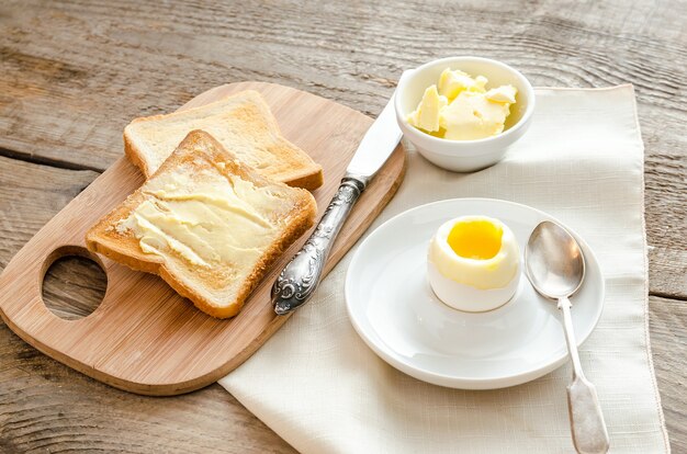 Gekookt ei met knapperige toast op de houten tafel