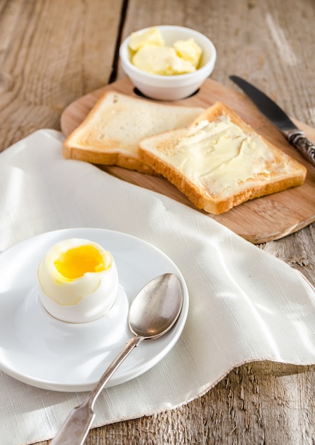 Gekookt ei met krokante toast op de houten tafel