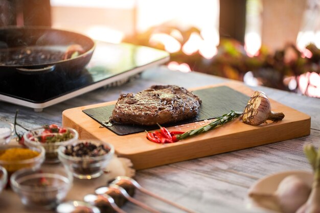 Gekookt vlees en rozemarijn. Chilipepers en geroosterde knoflook. Ribeye steak van sappig rundvlees. Meest heerlijke eten in restaurant.