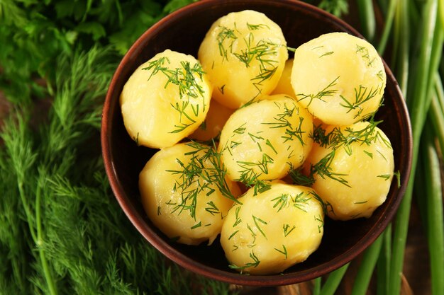 Gekookte aardappelen met groenen in kom op tafel close-up