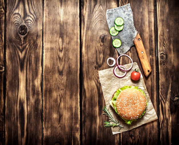 Gekookte Burger met groenten, kaas en vlees. Op houten achtergrond. Bovenaanzicht.