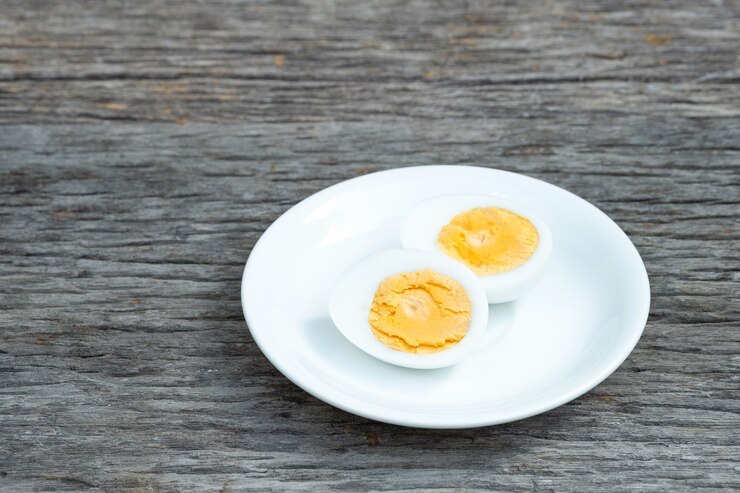 Gekookte eieren. Gekookte eieren in witte keramische plaat op houten tafel.