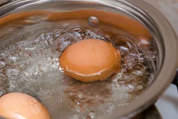 Gekookte eieren in een kleine steelpan.