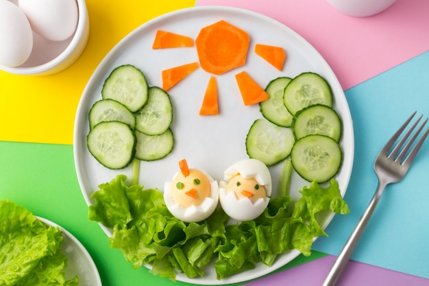 Gekookte eieren versierd als kippen, wortelzon en komkommerboom