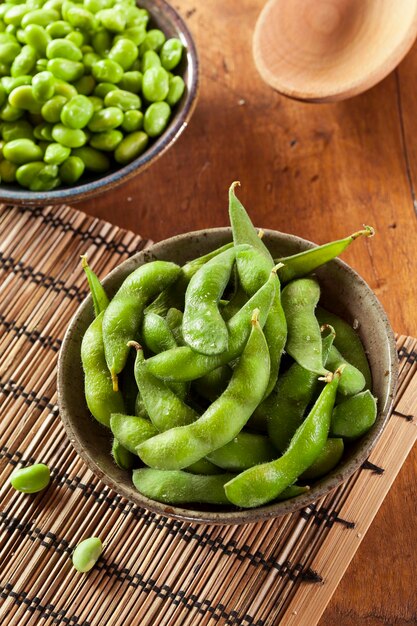 Gekookte groene biologische edamame met zeezout tegen een achtergrond