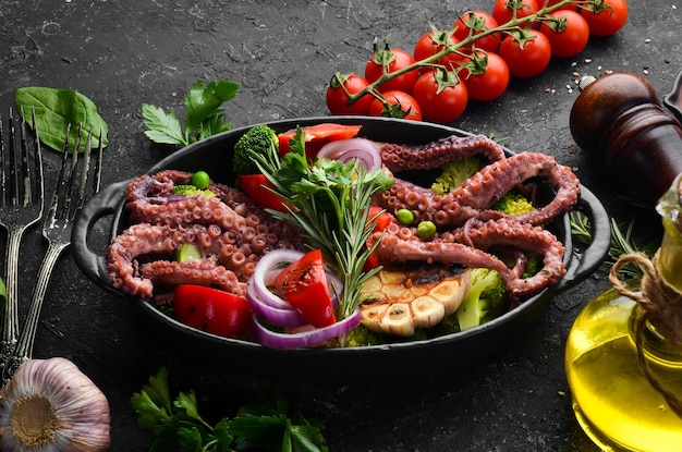 Gekookte grote octopus met gegrilde groenten in een zwarte stenen plaat Zeevruchten Bovenaanzicht Vrije ruimte voor uw tekst