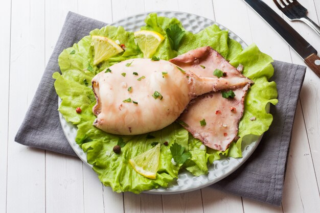 Gekookte hele inktvis op een bord. Seafood.