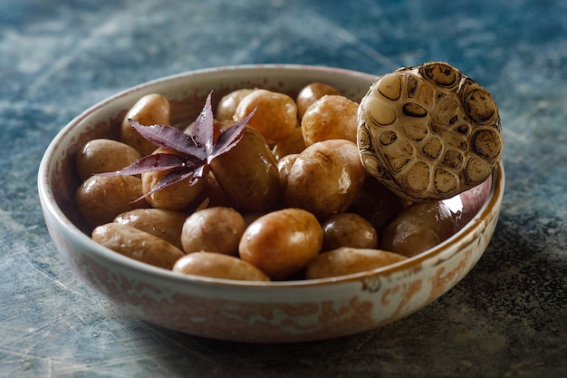 Foto gekookte jonge aardappelen met olie en geroosterde knoflook, in een houten schaal