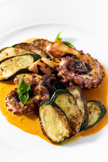 Foto gekookte octopus geserveerd met courgettes en saus