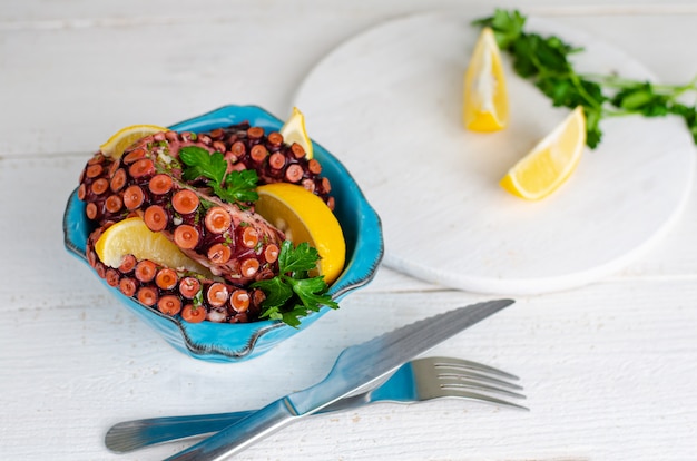 Gekookte Octopus met citroen en peterselie in een blauwe kom