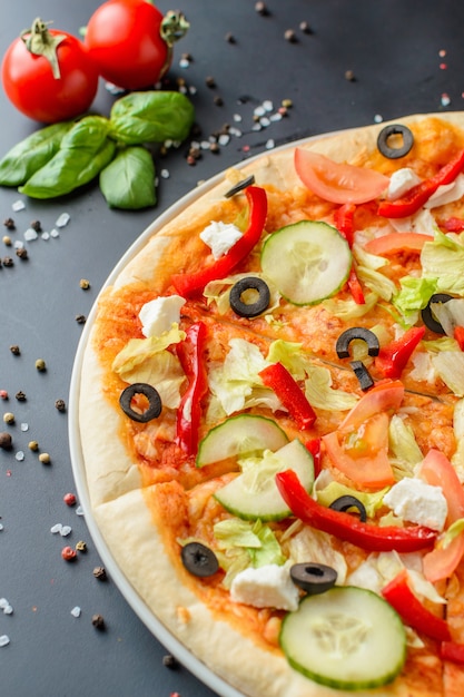 Gekookte pizza op dark met ingrediënten, close-up