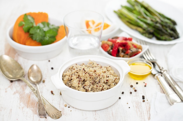 Gekookte quinoa en groenten op witte tafel